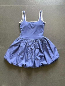 Flat lay of navy blue backless athletic tennis dress with white contrast trim detailing