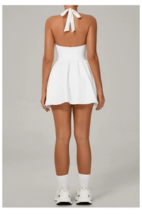 Back view of white halter neck tennis dress with backless design and pleated skirt
