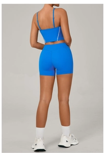 Back view of high-waisted blue sports shorts and strappy top with white side stripe details