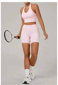 Vue détaillée de l'ensemble de yoga rose pâle avec haut licou et short de sport taille haute