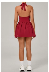 Detail of red backless tennis dress with halter neck ties and pleated skirt design