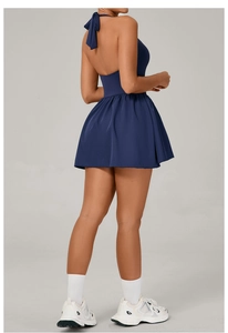 Detailed back view of a navy blue backless tennis dress with elegant pleated skirt hem
