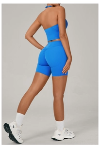 Détail du haut de sport asymétrique bleu Klein et du short de fitness effet push-up