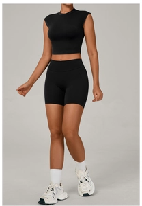 Close-up of black seamless yoga set fabric with high-waisted shorts and short sleeve top