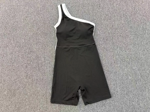 Détail d'une combinaison de yoga à une épaule avec passepoil blanc et tissu stretch noir