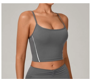 Detail of dark grey yoga crop top featuring thin shoulder straps and white side stripes