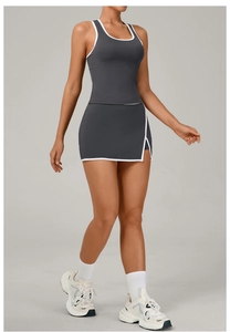 Detalle de la camiseta deportiva gris oscuro y falda de tenis con ribete blanco y abertura
