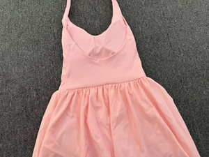 Flat lay detail of pink halter tennis dress showing waist fit and pleated skirt