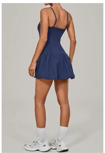 Rear view of navy blue tennis dress featuring a pleated bubble hem and cross-back straps