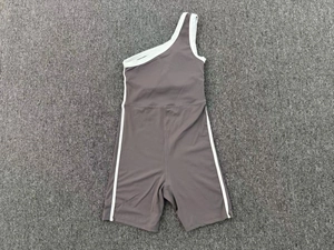 Vue détaillée à plat du combishort de yoga gris asymétrique avec bandes blanches