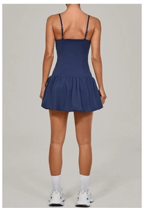 Back view of a navy blue sleeveless golf dress with a pleated skirt and thin straps