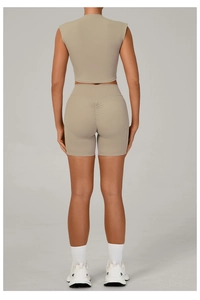 Detail view of high-waist scrunch butt shorts and matching sports crop top in beige