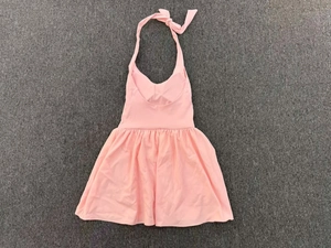 Flat lay of pink backless tennis dress with halter neck tie and pleated skirt detail