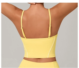 Detail of adjustable double straps and white side stripes on yellow sports bra