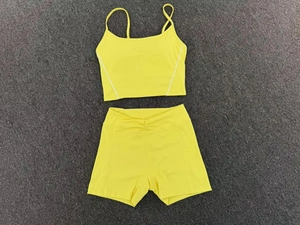 Flat lay of yellow two-piece yoga set with V-shaped waistband and white side stripes