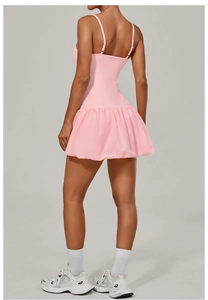 Detailed back view of pink backless tennis dress with cross straps and pleated skirt