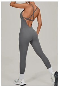 Detail of cross-back straps and open back design on a dark gray yoga bodysuit