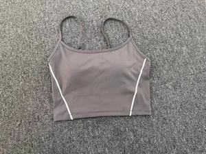 Detailed flat lay of dark gray sports bra with white side piping and thin straps