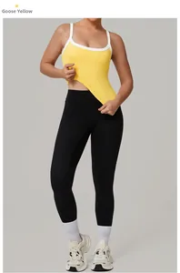 Dettaglio del gilet yoga giallo oca con profili bianchi e leggings neri a vita alta