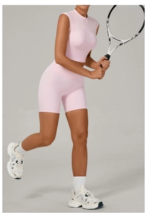 Detail of pink high-waisted fitness shorts and crop top on model with tennis racket
