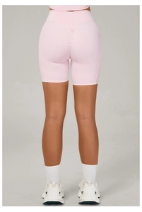 Détail macro du short de yoga rose à taille haute montrant l'effet push-up fessier