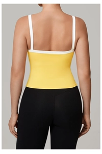 Dettaglio del top da yoga giallo con spalline larghe bianche e leggings neri a vita alta