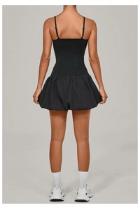 Back view of a sleeveless black bubble hem golf dress with slim straps and a fitted waist