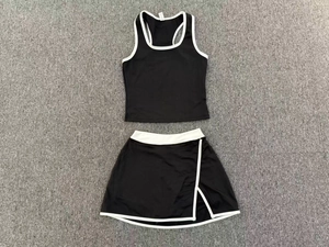 Detalle en plano de conjunto de tenis blanco y negro con top sin mangas y falda