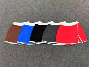 Vue à plat de cinq jupes de tennis colorées avec taille blanche et fentes latérales