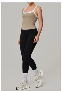 Dettaglio del top fitness marrone chiaro con bordo a contrasto bianco e leggings neri a vita alta