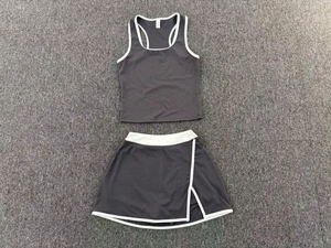 Detalle en plano de conjunto de tenis gris oscuro con ribetes blancos y top deportivo