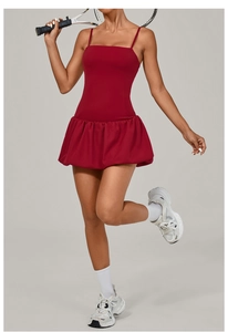 Detail view of the deep red athletic mini dress with a pleated puff hem and slim fit cut