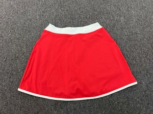 Vue à plat d'une jupe-short de sport rouge avec taille blanche et ourlet contrasté