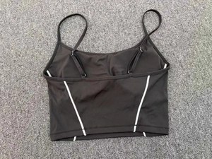Detail of adjustable straps and white contrast stitching on black yoga crop top