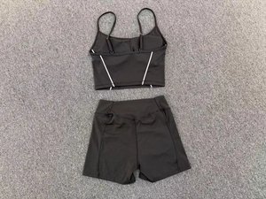 Detail view of black yoga set with cropped camisole and high-waisted gym shorts
