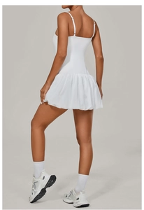 Detail of white sleeveless tennis dress featuring a pleated bubble hem and sporty design