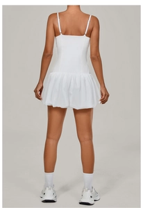 Back view of a white athletic dress showing thin straps and ruffled pleated hem detail