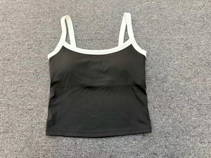 Dettaglio in piano del reggiseno sportivo nero da yoga con spalline bianche a contrasto