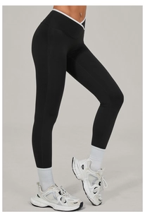 Detail of cross high waist yoga pants with white contrast piping and black elastic fabric