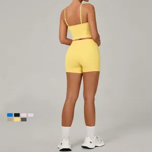 Women's yellow two-piece yoga set with cross back sports bra and high waist shorts