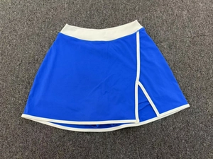 Détail d'une jupe-short de tennis bleu roi avec bordure blanche et fente latérale