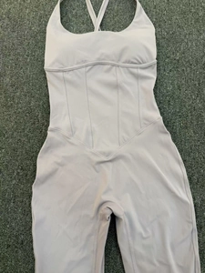 Detail of lavender yoga jumpsuit featuring corset-style stitching and criss-cross back straps
