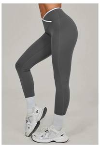 Macro detail of high-waist yoga pants with white V-cross waistband and charcoal fabric