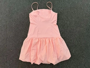 Detail view of pink tennis dress with adjustable spaghetti straps and bubbly hemline