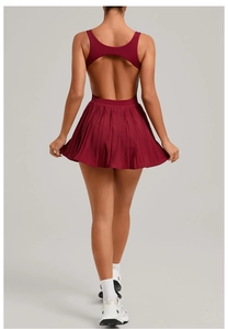 Detail of backless design and pleated hem on a deep red athletic tennis dress