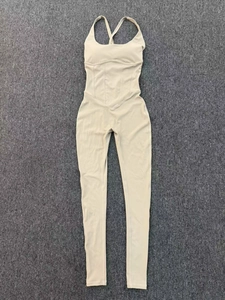 Flat lay of beige yoga jumpsuit featuring adjustable straps and compression waist detail