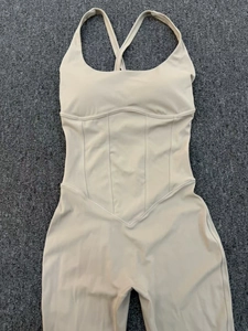 Detailed view of beige yoga bodysuit with V-waist stitching and adjustable straps