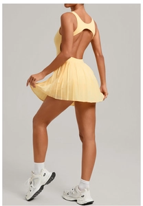 Detail view of the backless lemon yellow tennis dress with pleated skirt and back cut-out