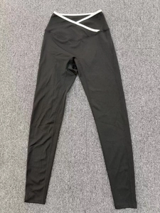 Detail view of V-shaped crossover high waist with white trim on black yoga leggings