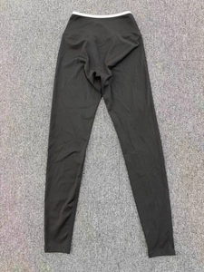 Detail shot of black high-waisted yoga leggings featuring a contrast white waistband trim